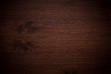 Close up view of dark brown wooden surface showing natural grain pattern and texture details suitable for backgrounds or design materials