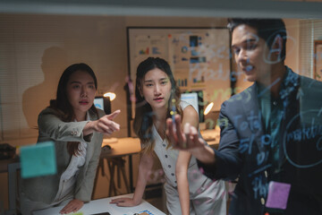 Business team collaborating on planning using a glass board