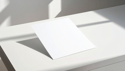 Blank white paper card placed on a white surface with soft shadows and natural light