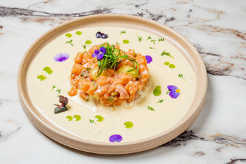 Artfully arranged salmon tartare, garnished with herbs and flowers, showcases culinary artistry