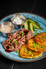 Savor pulled beef, golden potatoes, and fresh cucumber slices with creamy dips