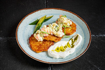 Crispy potato pancakes topped with seafood salad, fresh herbs, and creamy dressing