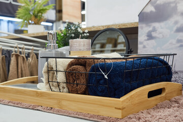 Multicolored towels are lying in a basket on a store shelf.