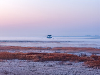 Sunrise over wetlands, morning mist, Chinese-style pavilion