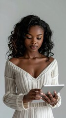 Fototapeta premium Young African American woman focused on her digital tablet.