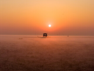 Sunrise over wetlands, morning mist, Chinese-style pavilion