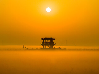 Sunrise over wetlands, morning mist, Chinese-style pavilion