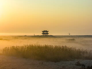 Sunrise over wetlands, morning mist, Chinese-style pavilion
