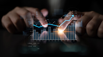 Business professional engages with digital graphs and charts, illustrating financial analysis and market trends in a contemporary office setting. Scalp