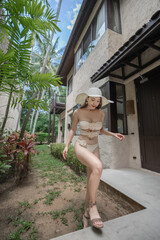 Woman in sexy bikini with tropical garden background.