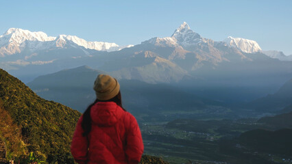 Fototapeta premium Blurred rear view of a woman traveler looking at Machapuchare peak, Annapurna mountain range in Pokhara , Nepal