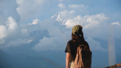Blurred rear view of a woman traveler with Machapuchare peak, Annapurna mountain range in Pokhara , Nepal