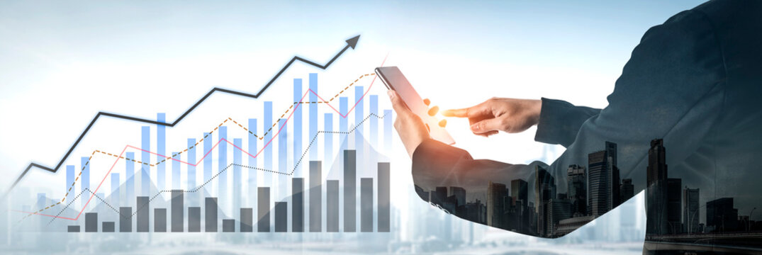 This image captures a business professional using a smartphone while engaging with a growing graph, symbolizing financial success and technology role in modern urban environments. Scalp - Powered by Adobe