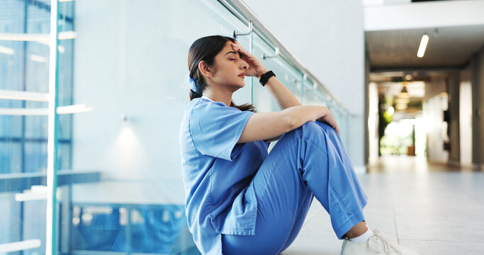 Nurse, woman and stress on hospital floor with healthcare crisis, medical mistake or treatment fail. Mental health, nursing intern and overwhelmed in clinic hallway for patient loss, anxiety or worry