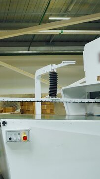 Silent highprecision equipment for folding, adhering cardboard components, White industrial apparatus used within contemporary factory for automated cardboard assembly processes