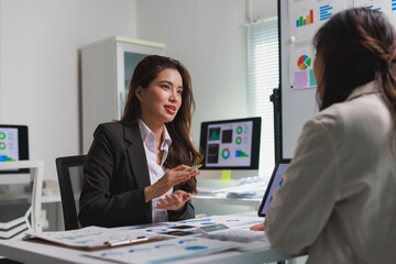 Businesswomen discussing data analysis during an office meeting