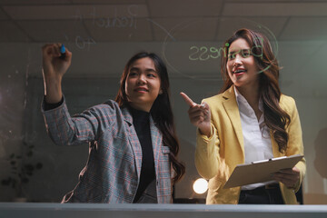 Businesswomen collaborating on glass board developing new ideas