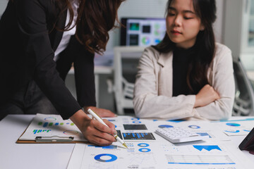 Businesswomen analyzing financial data on documents in meeting