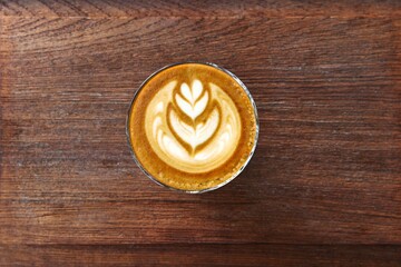 a cup of latte art coffee on wooden background                                                                      