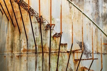 old rusted stairs on a storage tank
