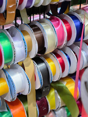 Colorful satin ribbon spools and shiny rolls for creative craft project. vibrant material for sewing, decoration, gift wrapping, and haberdashery supply in shop