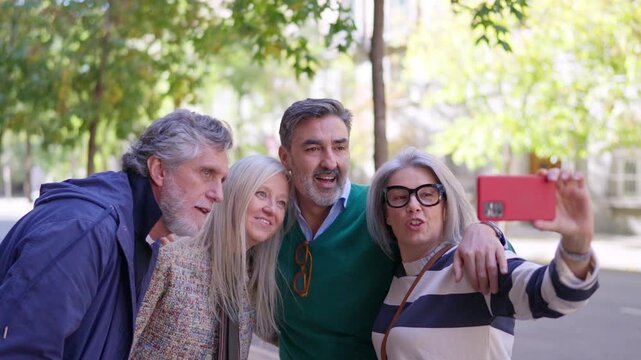 Senior couple taking a selfie with a smartphone outdoors - Powered by Adobe