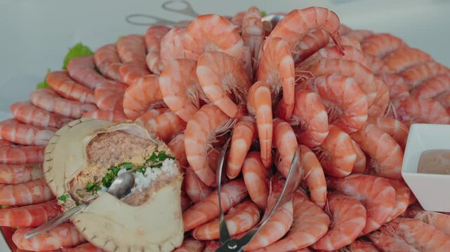 vibrant pile of prawns arranged around a stuffed crab on a chilled platter