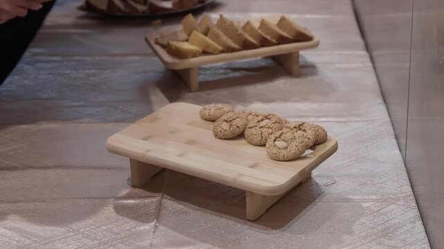 hand picking up cookie from wooden tray in casual buffet setup