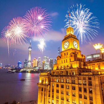 Illuminated urban scene with fireworks exploding over the waterfront