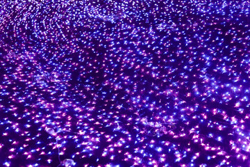 Glowing purple and blue abstract background of light sparkle with bokeh effect. An enchanting violet display perfect for magical night scene or festive wallpaper