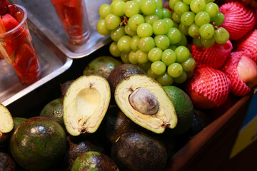 Fresh cut avocado and green grape display at fruit market. Healthy, delicious, and natural food choice for vibrant lifestyle, offering organic vitamins and nutrition