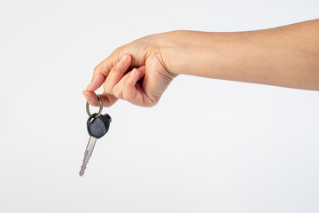 A black motorcycle key in a hand against a white background.