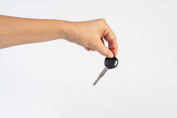 A black motorcycle key in a hand against a white background.