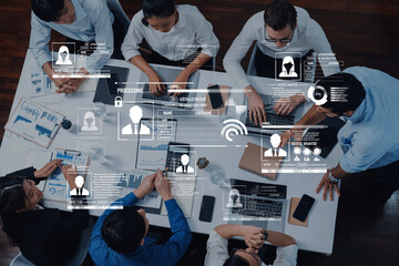 Professionals engage in a business meeting surrounded by technology, analyzing data on screens. The modern office setting promotes collaboration and innovative strategy. Trope