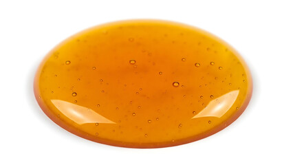 Shiny viscous golden liquid puddle isolated on white background, sweet food ingredient