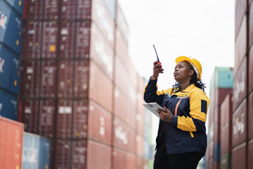 Portrait African woman logistics workers use notebook computer and walkie talkie checking container	