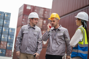 Engineer and worker team working in logistic terminal of container cargo, Diverse construction team in safety gear outdoors	