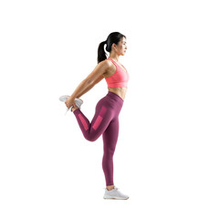 Woman stretches leg while standing in workout attire in a bright space during the day for fitness training