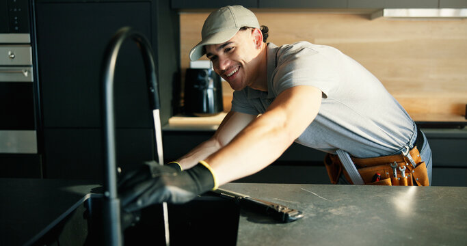 Faucet, maintenance and repair with plumber in kitchen of home for installing or testing water supply. Checking, plumbing fix and tap with man in apartment for inspection or renovation as contractor