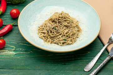 pasta with cheese in a plate on a green table