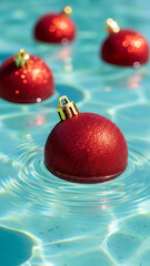 Red Christmas Ornaments Floating on Clear Blue Water in a Swimming Pool, Fun Tropical Holiday Concept with Bright Summer Light
