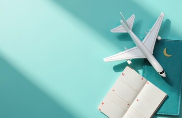 Toy airplane, passport, and ticket lie on bright blue surface. White plane model with teal passport and open itinerary suggest summer vacation planning or travel booking.