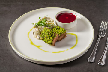 Fine-dining pistachio lamb back served with creamy side dish
