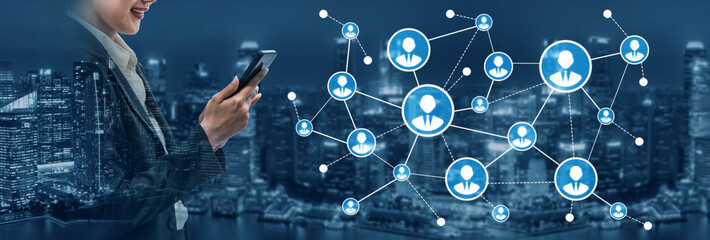 A professional woman interacts with a smartphone, engaging with a digital network of user profiles. The city skyline at night enhances the modern technology theme. Tessel