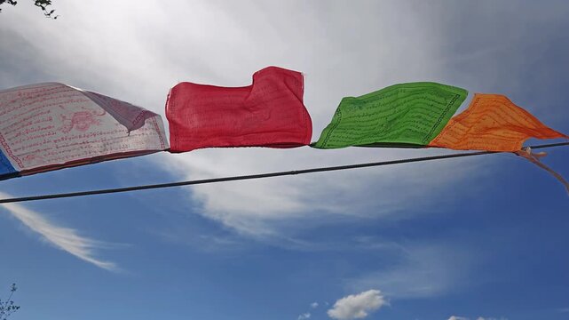 Slow motion video of Religious tibetan buddhist prayer flags in Altai Chiketaman mountain pass. Flags are flutter in the wind on blue sky background.