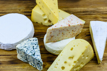 Various types of cheese on a wooden background