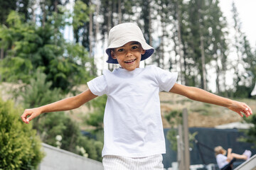 young mixed-race boy smiles while running towards trampoline
