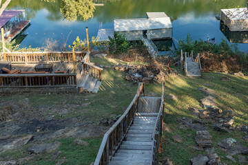 shaded hillside looking out at lake with a man fishing from boat