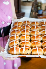 Freshly Baked Hot Cross Buns on Tray Held by Woman in Pink Dress
