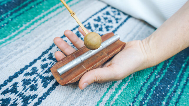 Hand holding a single chime for sound healing and meditating